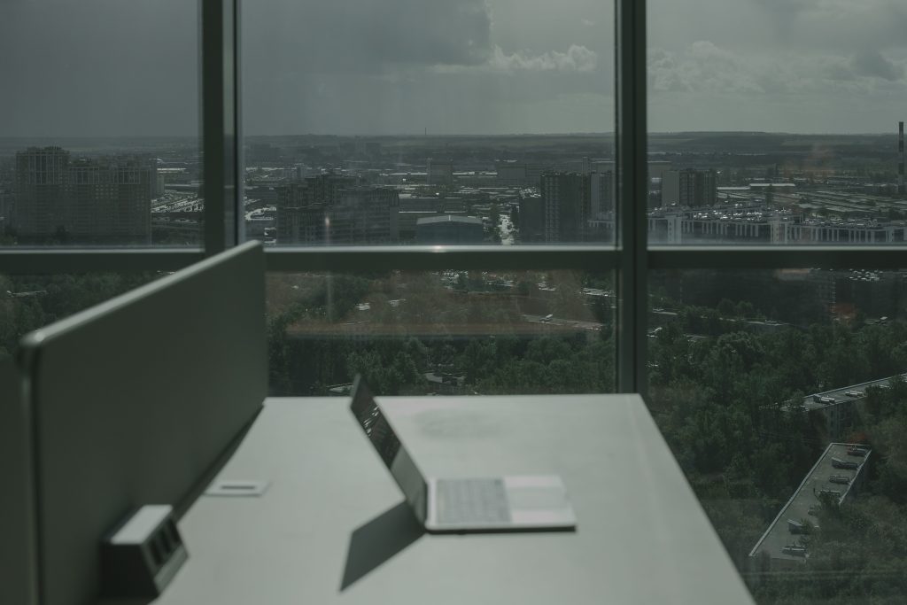 Modern office desk with laptop overlooking city skyline